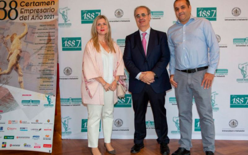 Foto de tres personas junto a estandarte del Certamen de empresario del añño 2021