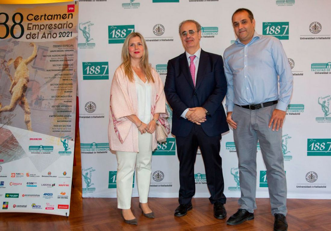 Foto de tres personas junto a estandarte del Certamen de empresario del añño 2021