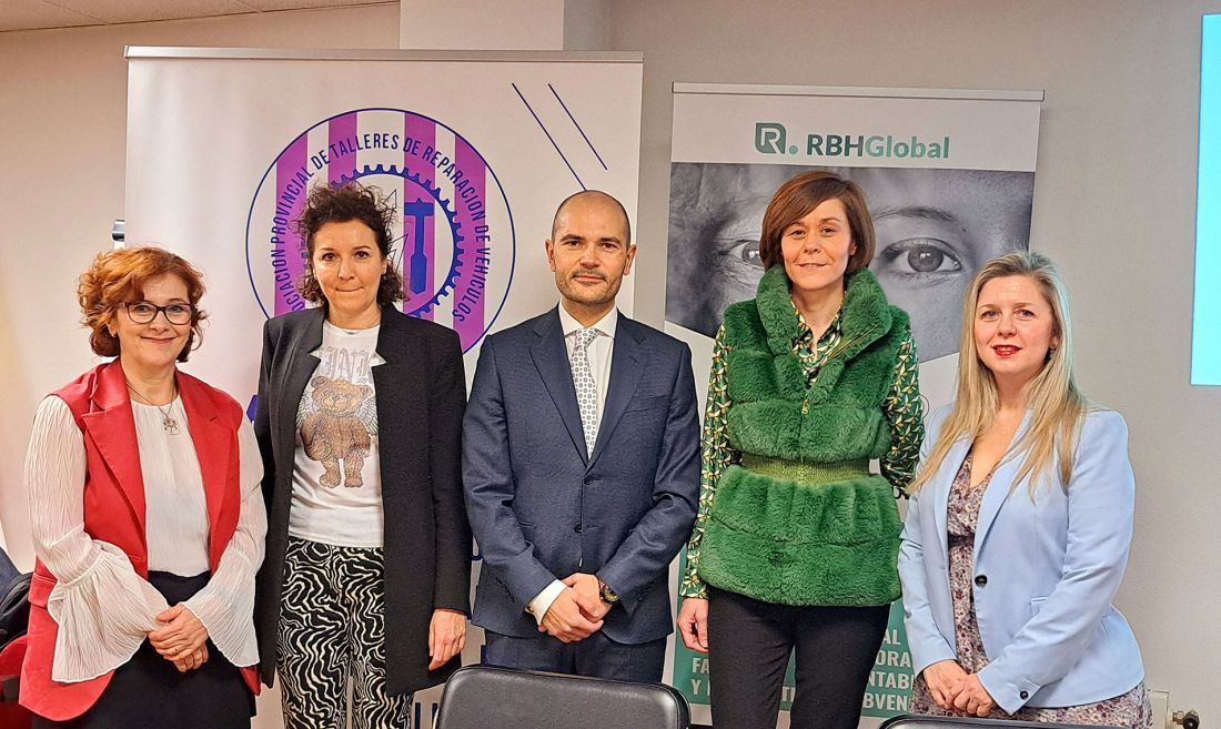 Foto grupal delante de estandartes con logotipos de asociación de talleres de reparación de vehículos de valladolid y RBH Global